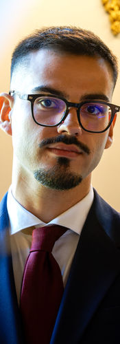 Portrait couleur d’un invité en costume lors du mariage civil d’Annapaola et Angelo à la mairie du 7e arrondissement de Paris. La lumière naturelle met en valeur son regard attentif pendant la cérémonie, illustrant la solennité et l’émotion de ce moment, capturé par Colombe Photographie, photographe de mariage civil à Paris et en région parisienne.