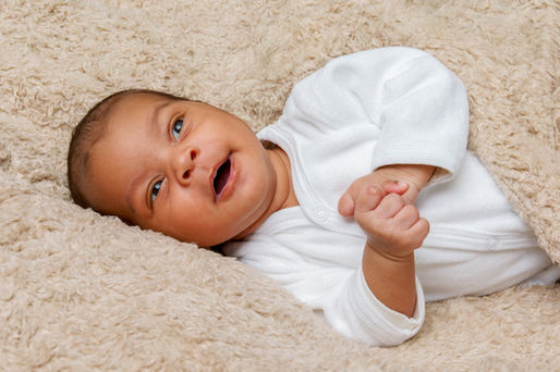 Portrait rapproché d’un nouveau-né éveillé, allongé dans une couverture moelleuse lors d’une séance photo en studio à Gentilly. L’expression douce et curieuse du bébé crée une image naturelle et intemporelle. Photographe nouveau-né en région parisienne, spécialisée dans les portraits délicats et lumineux.