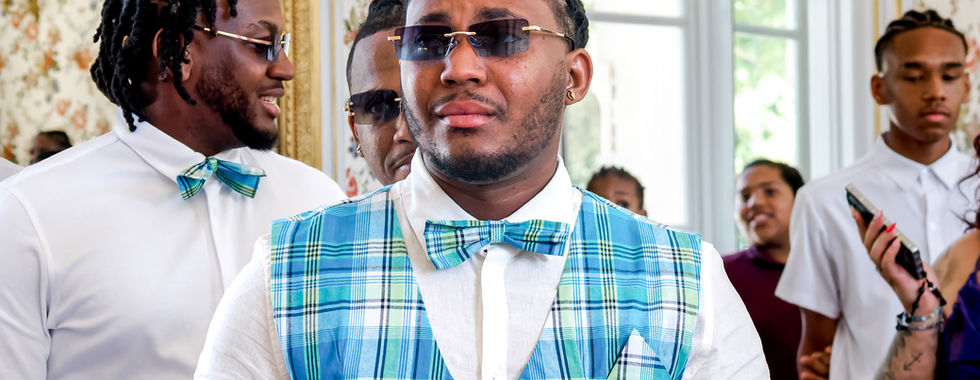 Portrait d’un invité au look soigné lors du mariage civil de Mallory & Ruddy, en Île-de-France. Il porte une tenue coordonnée en tartan bleu et vert avec nœud papillon, assortie à celle du marié. Photo prise par Colombe Photographie, photographe de mariage à Gentilly et en région parisienne, spécialisée dans les reportages authentiques, les portraits naturels et les cérémonies multicolores et multiculturelles.