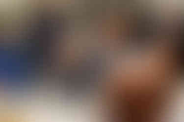 Photo prise pendant les discours lors de l’anniversaire surprise des 50 ans d’Armel. Un invité applaudit avec enthousiasme en tenant une coupe, entouré de convives souriants et attentifs. La scène illustre la joie partagée et les interactions spontanées lors du repas. Reportage réalisé par Colombe Photographie, photographe d’événements familiaux à Gentilly et en Île-de-France.