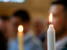 Gros plan sur un cierge allumé, représentant la lumière de la foi chrétienne, capturé lors de la cérémonie de baptême. Cette image symbolise la présence divine et la purification de l'âme, un élément sacré du rituel religieux, essentiel dans le baptême chrétien.