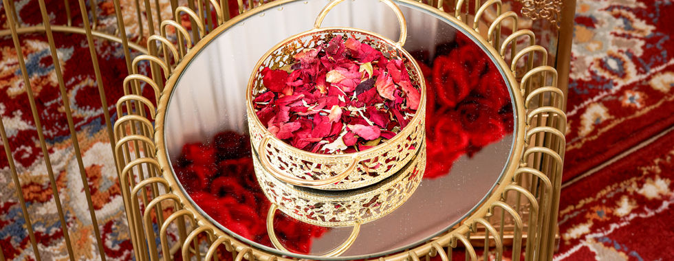 Décoration de mariage kurde-tunisien avec pétales de roses rouges dans une coupelle dorée posée sur une table miroir, photo de détails par Colombe Photographie à Saint-Gratien.