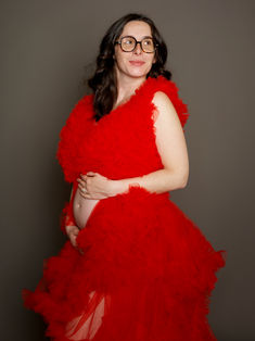 Portrait artistique de grossesse en studio avec robe rouge, réalisé à Gentilly en région parisienne. Mise en scène élégante et créative pour sublimer la maternité avec des images fortes et esthétiques. Colombe Photographie, studio photo en Île-de-France, propose des séances grossesse artistiques et personnalisées pour créer des souvenirs uniques.