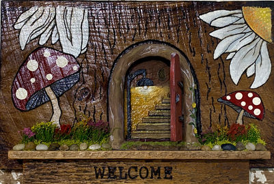 Handcrafted barn wood fairy house surrounded by mushrooms.