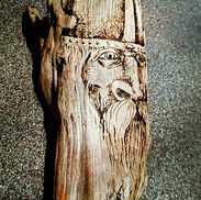 Face of a Viking on driftwood.