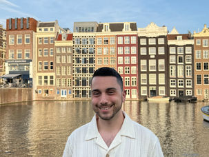 ragazzo sui canali di amsterdam con case sullo sfondo