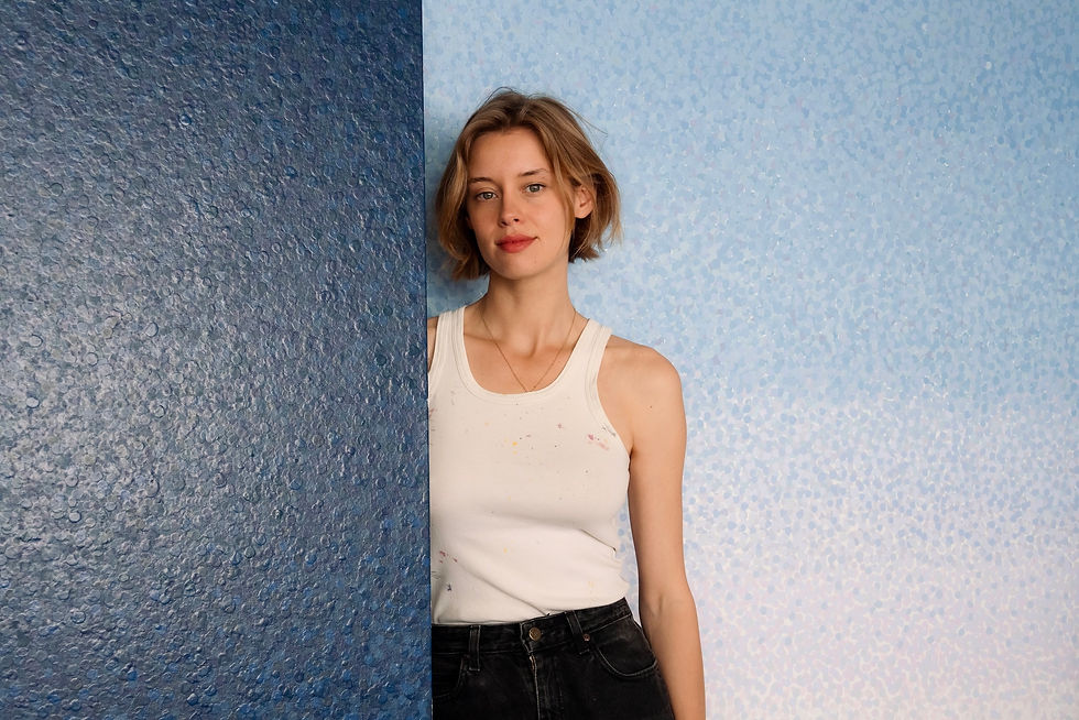 Cyrielle Gulacsy’s self-portrait with her paintings, 2025