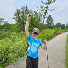 camper with fishing pole and fish