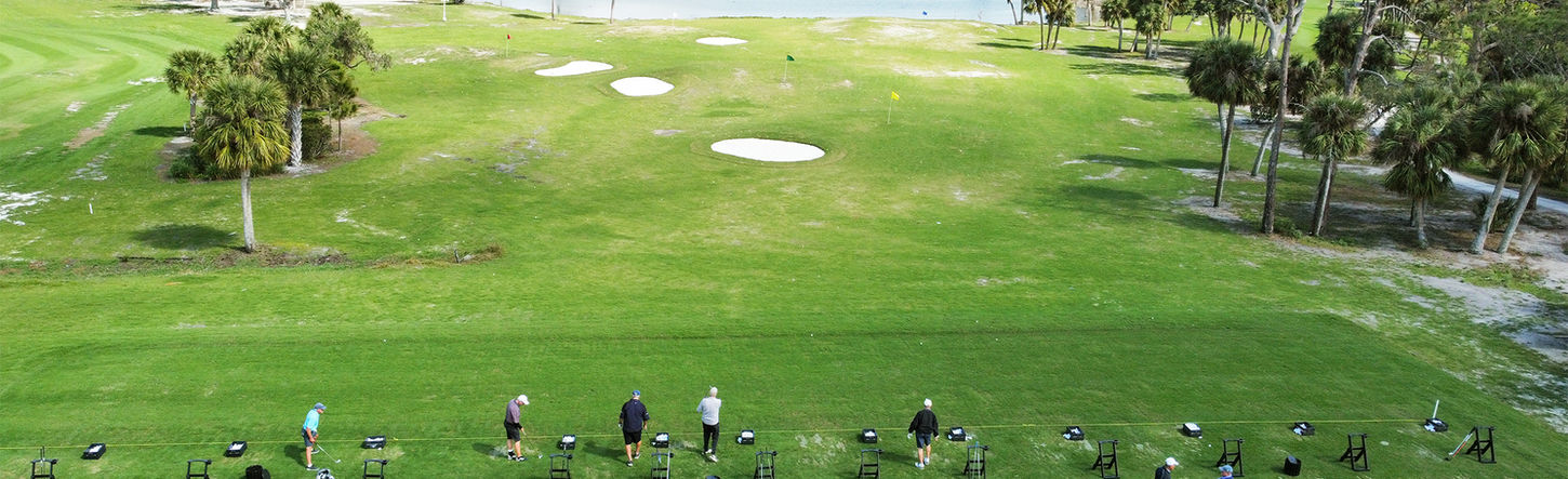 A driving range with homes in the distance