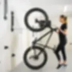 Woman hanging bike on wall rack in transformed garage