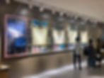 「沈みゆく船からの手紙」と題された展示を見る3人の訪問者