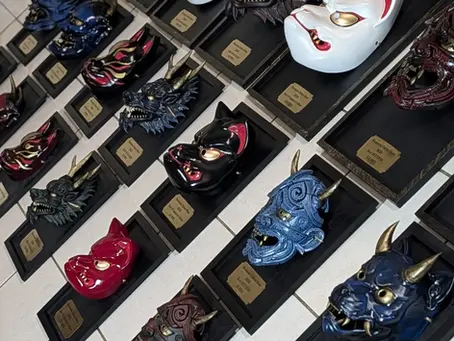 21 masques japonais trophées faits main par Dai Yokai pour le Besançon International Tattoo Show 2026, alignés sur cadres en bois avec plaques gravées dai yokai