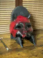 Demi-masque Kuchisake japonais artisanal, cornes noires et dentition saillante, finition vernis brillant, sur support en PETG