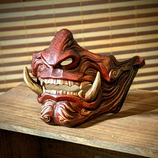 demi-Masque Oni rouge porté en cosplay ou exposé dans un tattoo shop, inspiration de tatouage japonais Irezumi