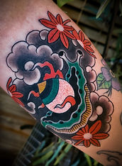 tattoo of Japanese snail with Hoju for a shell and clouds and flames in the bacground
