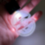Smiley Face with Mushroom LED Keychain glowing white in hand