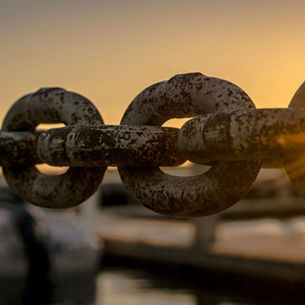 Schakels die in elkaar klikken en samen een geheel vormen, metafoor voor samenwerking die ontstaat door gedrag en afstemming tussen teams en organisatiecontext.