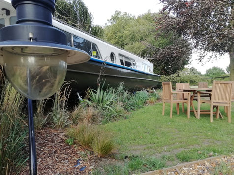 Woodland Boat exterior with seating area and surrounding rural landscape
