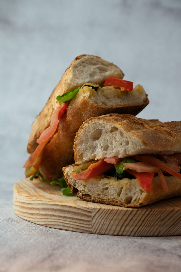 Food Photography of a Panino filled with hummus, grilled vegetables and rucola.