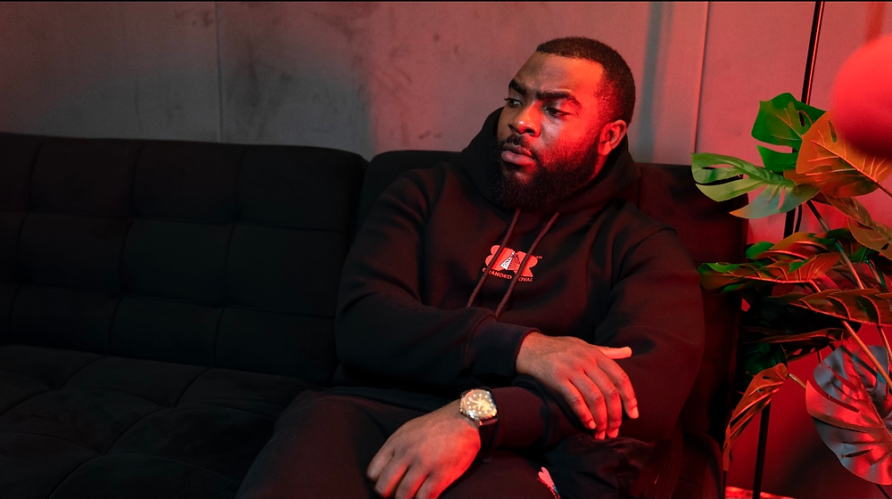 Ope Oworu Branded Royal Fashion Black Tracksuit Black Hoody Black Oversize Hoody Black Pants Red Logo Jungle Bean Studio Streetwear Fashion Ireland Dublin High Fashion Red Colour Couch Sofa