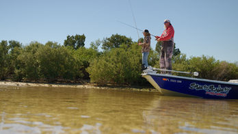 Caution Glass filming two men fishing off of a boat on the water