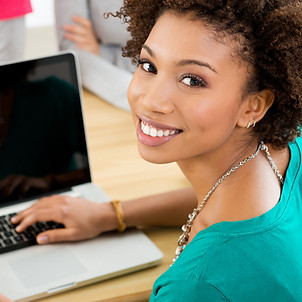 Young professional smiling and working on laptop