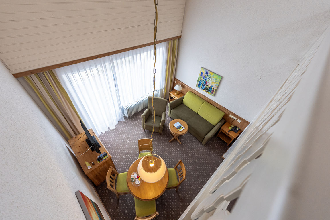 High-quality holiday apartment: living area with sofa, table and chairs