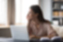 Dreamy young woman pondering ideas, sitting at desk with laptop, distracted from work, bea
