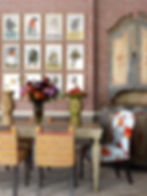 This is a close up of the dining area of the room above showing the walls in red block print, and the dining chairs in the same print on a yellow ground.
