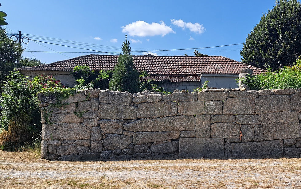 Muro de pedra secular em frente de uma casa antiga no Lugar do Eido