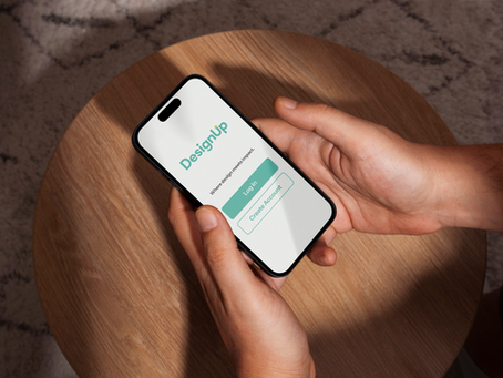 Phone being held by a male hand with DesignUp login screen pulled up