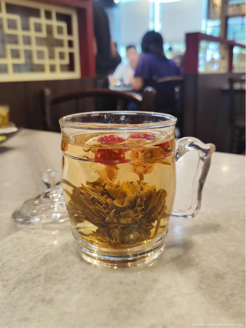 A cup of Blooming Jasmine Water, a tea from Wok Master infused with Jasmine flowers and leaves.