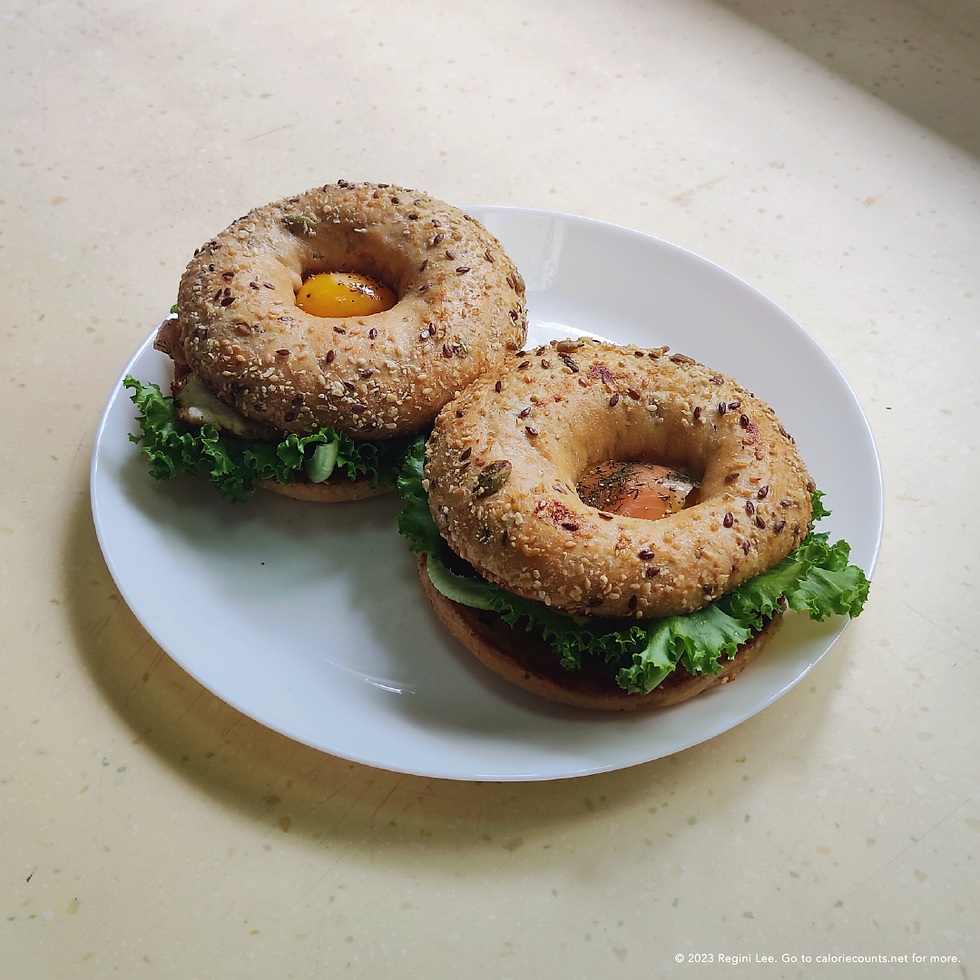 Grains and seeds sourdough bagel sandwiches with lettuce, sunny side-up, smoked salmon, sprinkled with a dash of salt and pepper.