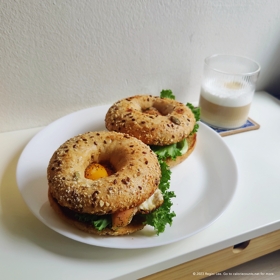 Grains and seeds sourdough bagel sandwiches with lettuce, sunny side-up, smoked salmon, sprinkled with a dash of salt and pepper.