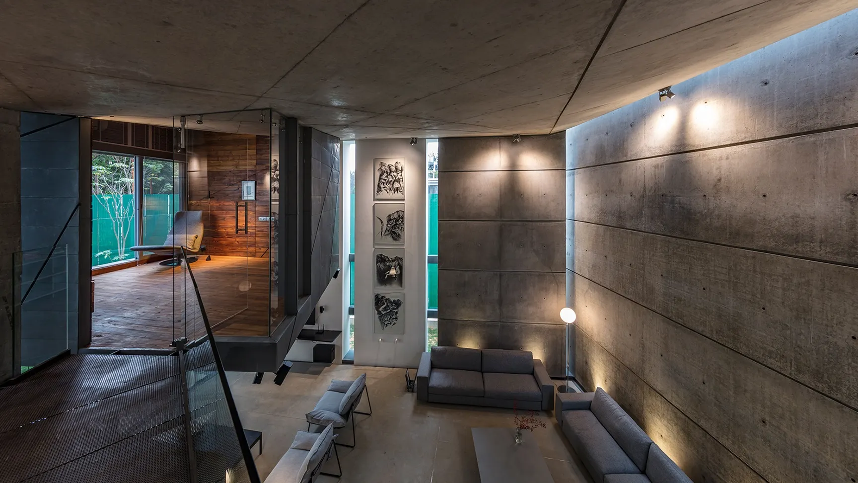 A metal and glass bridge connects the living room with the library, appearing to be suspended mid-air above the living room at House of Stories, Bangalore by Melange Interiors