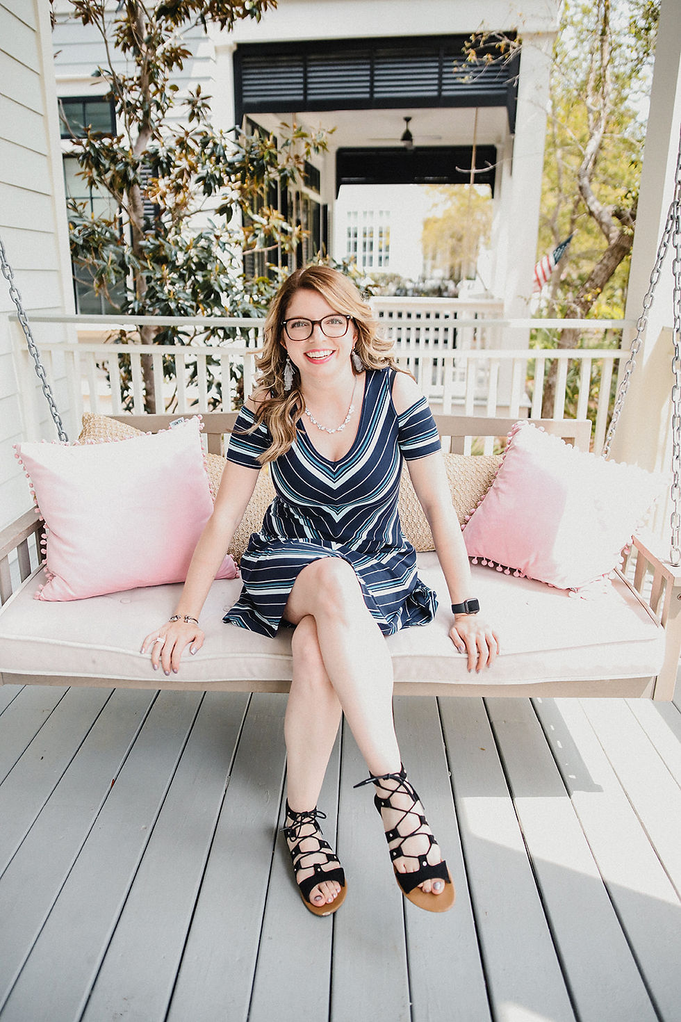Taylor Murphy of By Taylor Murphy smiling on a porch swing with pink pillows — Easy Peasy VA client testimonial photo