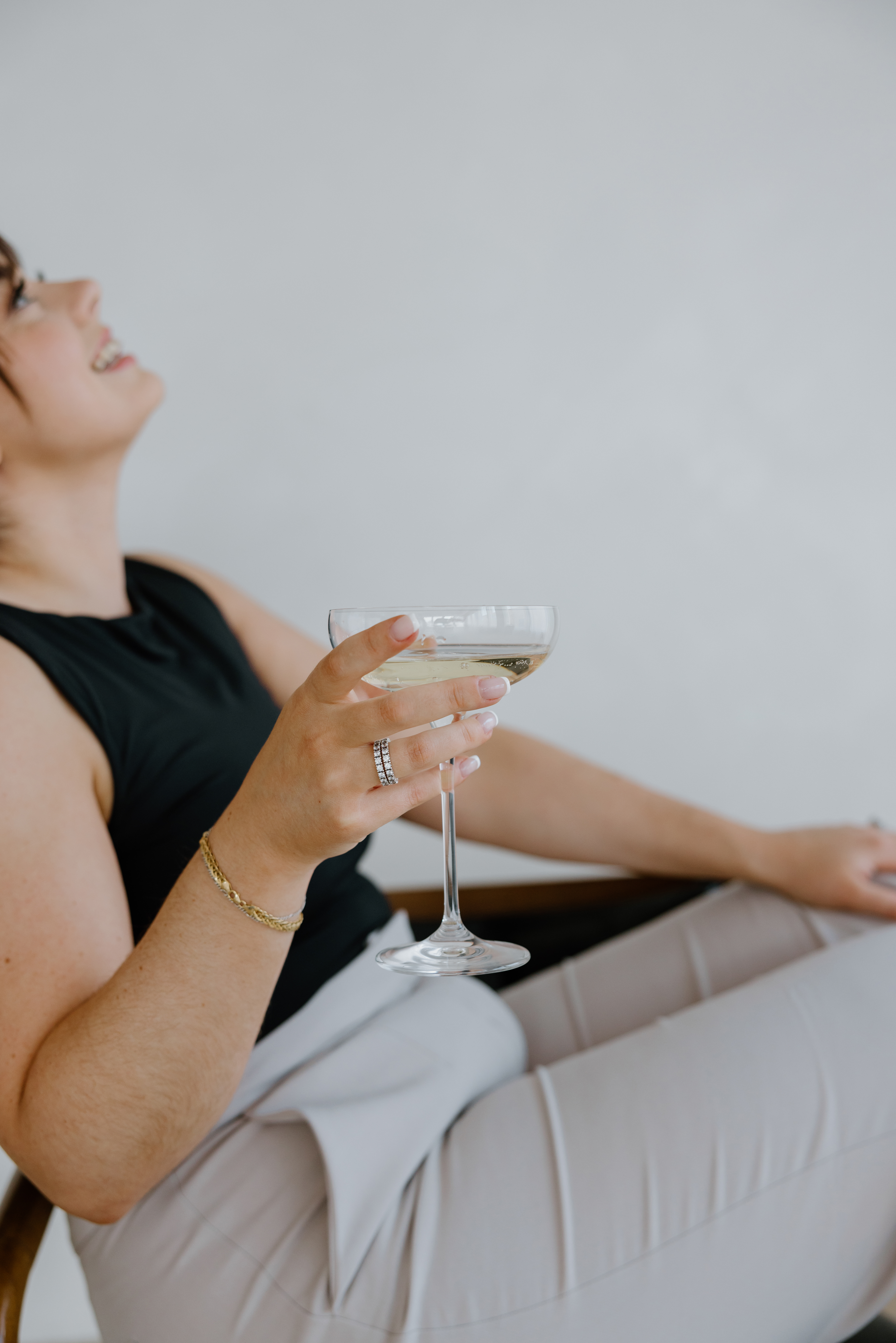 Paige, founder of Easy Peasy VA, laughing and relaxing with a glass of champagne