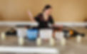Sound healer surrounded by crystal singing bowls and candles