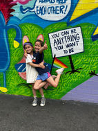 Kids hugging in front of mural