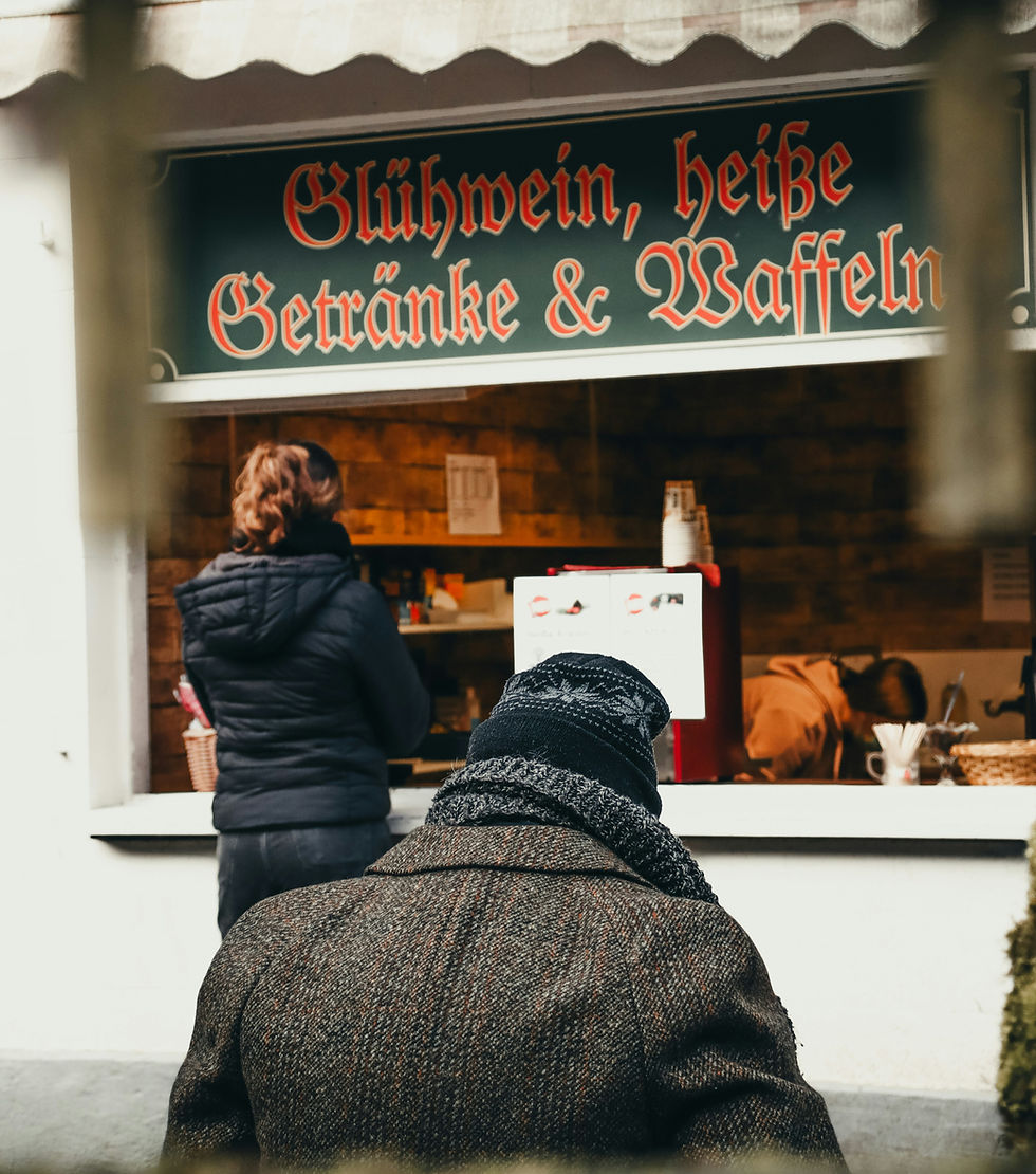 Warming up at the Monschau Christmas market, visitors enjoy mulled wine and waffles.