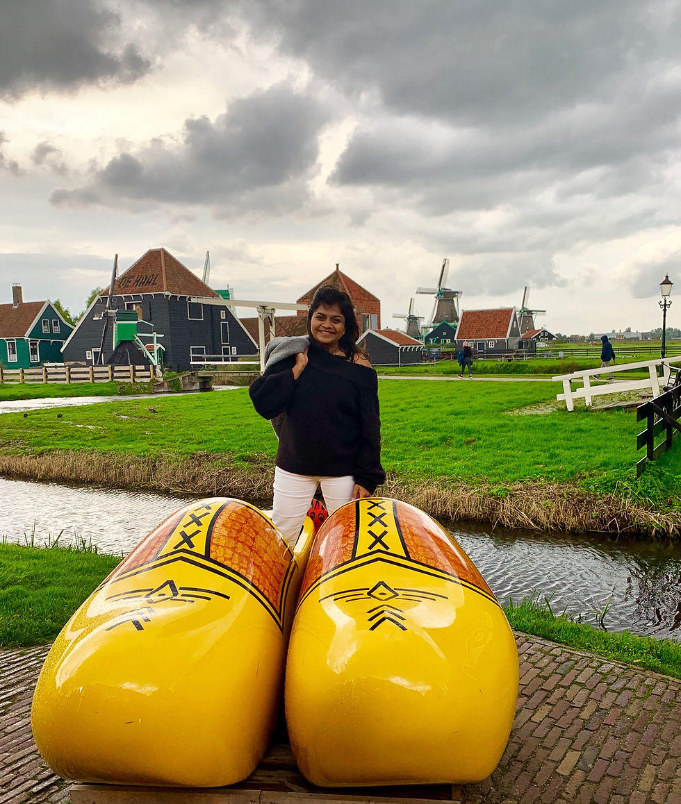 Exploring the charm of Zaanse Schans, with its iconic windmills and oversized clogs, amidst a backdrop of picturesque Dutch countryside.