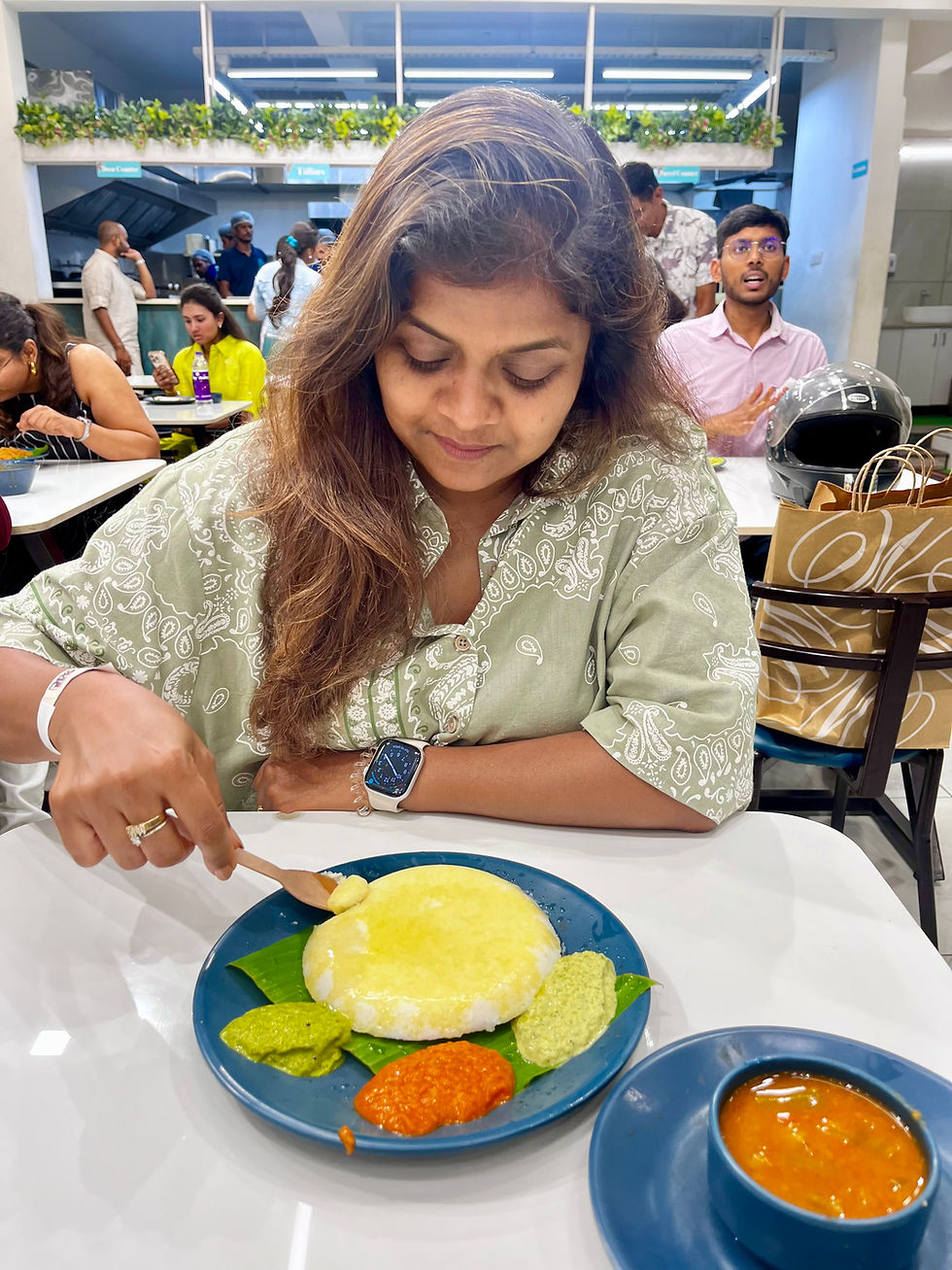 Relishing a a soft, steaming idli with a variety of vibrant chutneys and sambar at Cafe Amudham