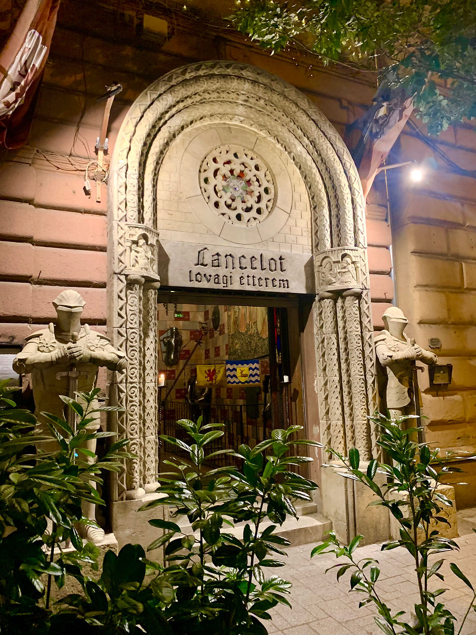 Entrance to the medieval-themed "Lancelot Knights Restaurant," featuring ornate stonework and knight statues, inviting guests to step into a world of chivalry and history.