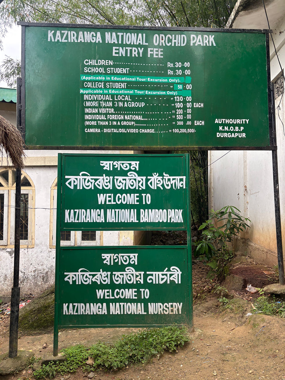 Entrance signs detail entry fees for the Kaziranga National Orchid Park, alongside welcomes to Kaziranga National Bamboo Park and Nursery.