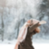 Traveler walking through snowy mountain resort, symbolizing winter marketing campaign inspiration for hotels.