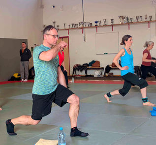 Homme et femme effectuant des fentes pour le renforcement musculaire.