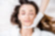 Woman receiving a botox injection in the eye zone lying in bathrobe on the medical couch.j