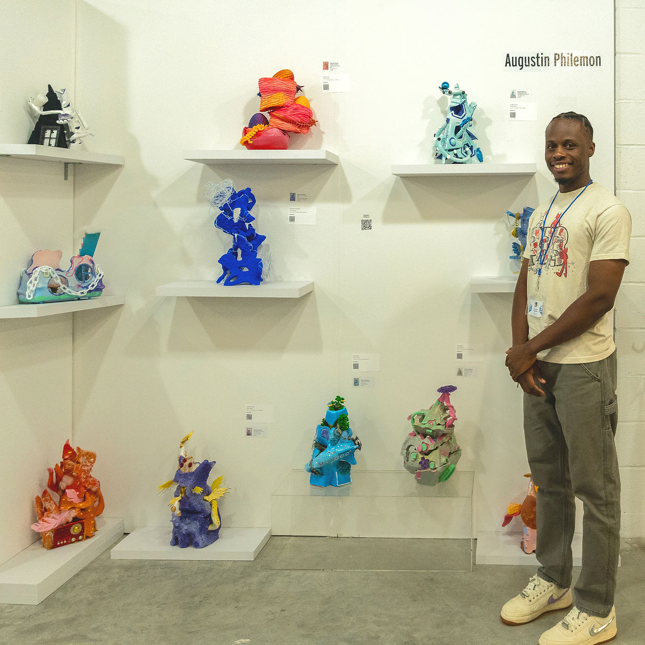 Artist Augustin Pjilemon in front of his sculptures showcased at Clio Art Fair's 19th Edition