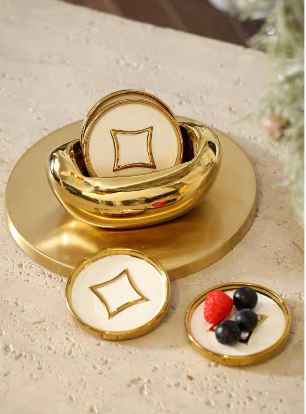 Gold coasters with decorative bowl and berries on a golden platter