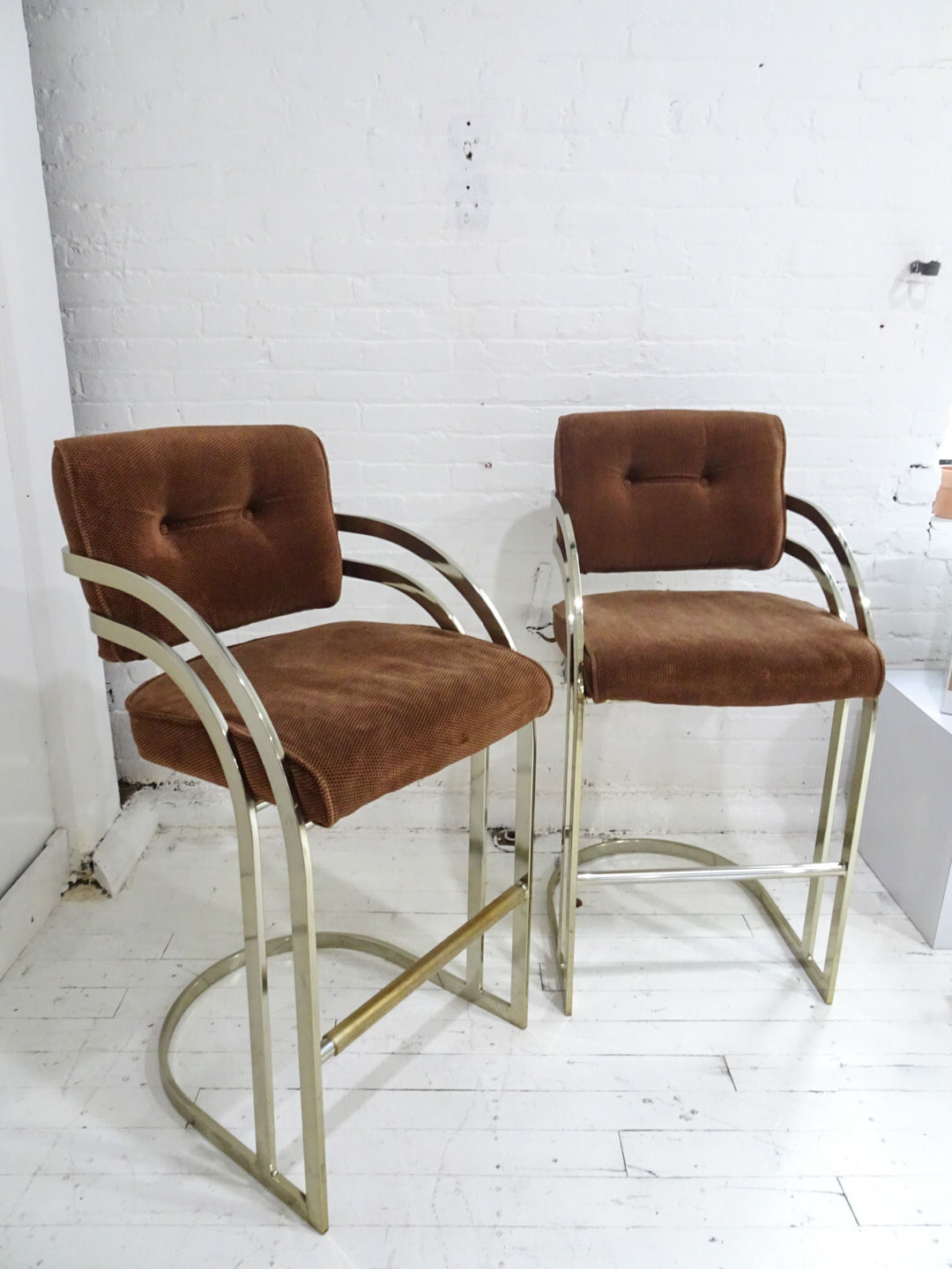pair of 1980s brass bar stools with deep brown upholstery